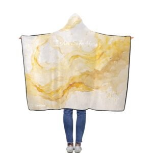 A person stands with their back to the camera wearing a hooded blanket printed with soft golden abstract shapes on a pale background. Across the upper back, the phrase “I Am Safe Here” appears in gentle script. A small QR code and the words “Core Guide” sit quietly in the lower left corner, creating a discreet portal to a private audio experience.